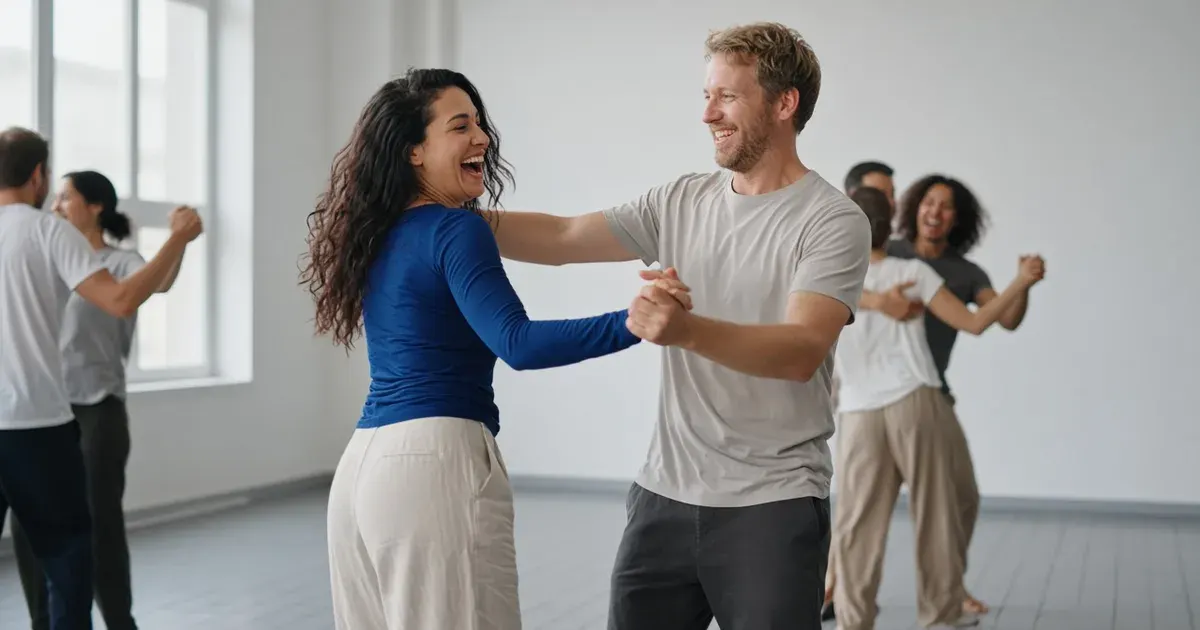 A couple laugh at their clumsy steps in a bright dance studio, the woman in a cobalt top mid-spin.